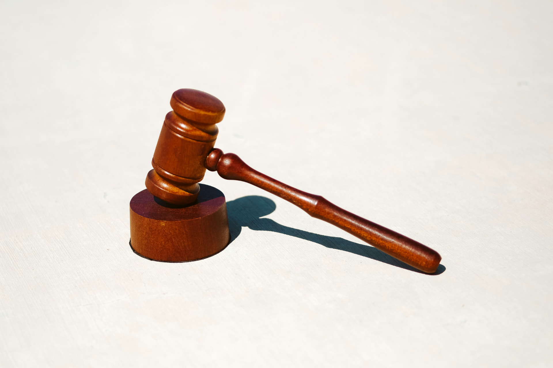 A wooden judge’s gavel resting on a light surface